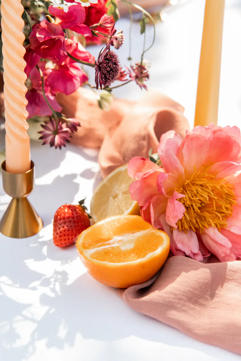 Détail de pivoine corail, agrumes et bougies