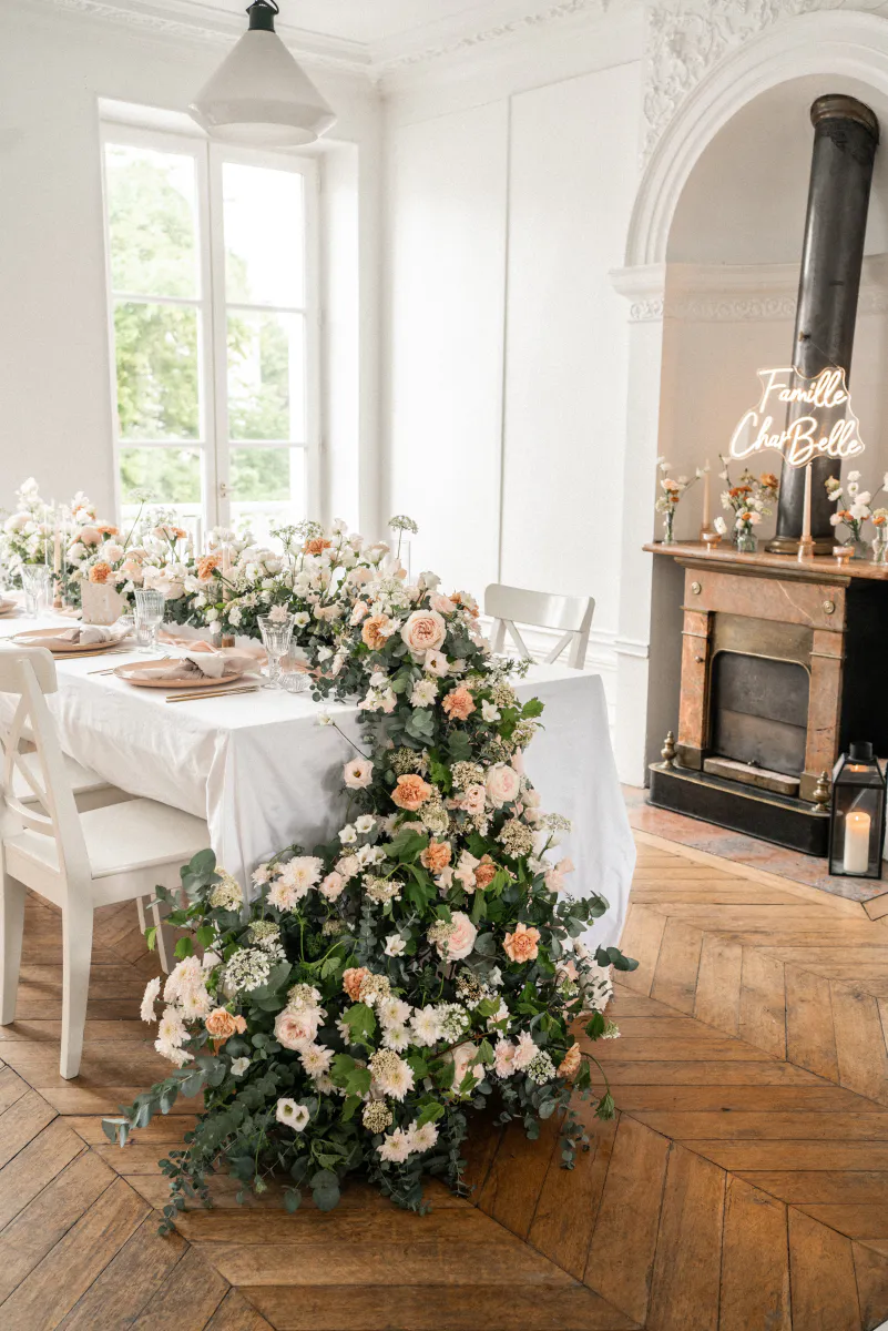 Table dressée avec guirlande florale blanche et pêche
