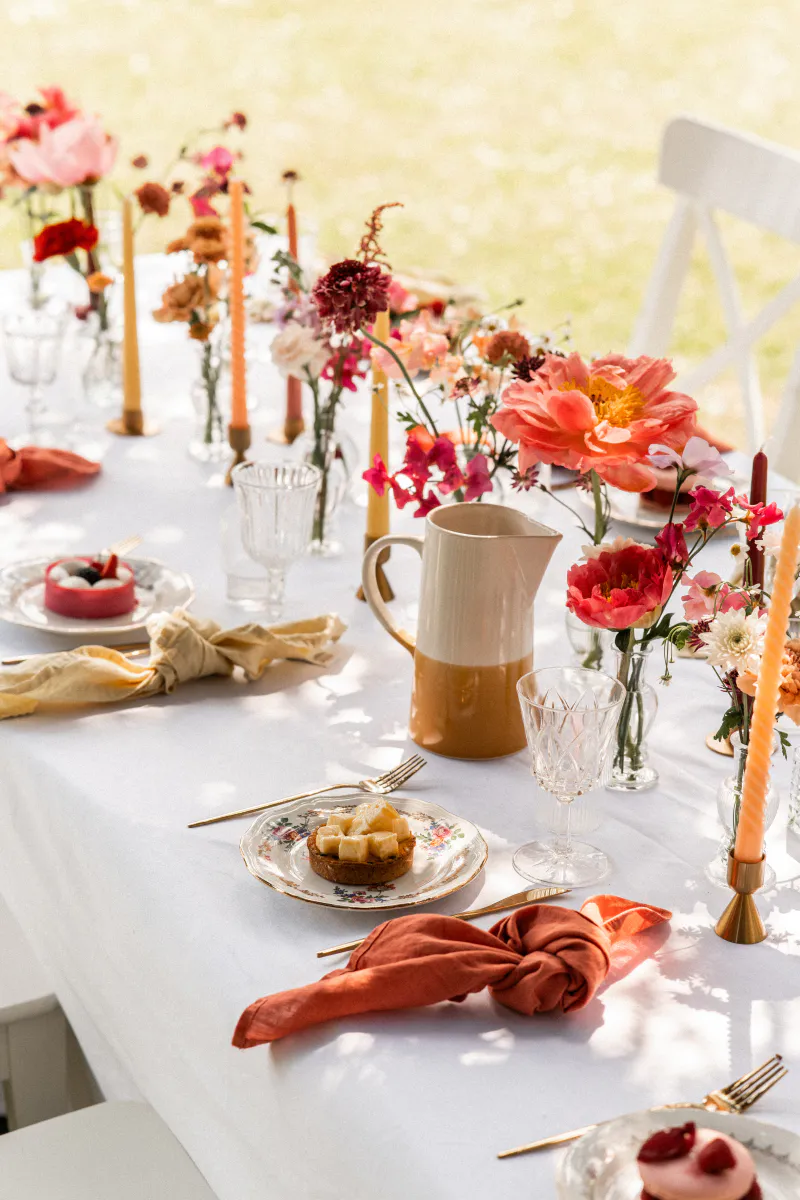 Table de fête aux fleurs vives et bougies colorées