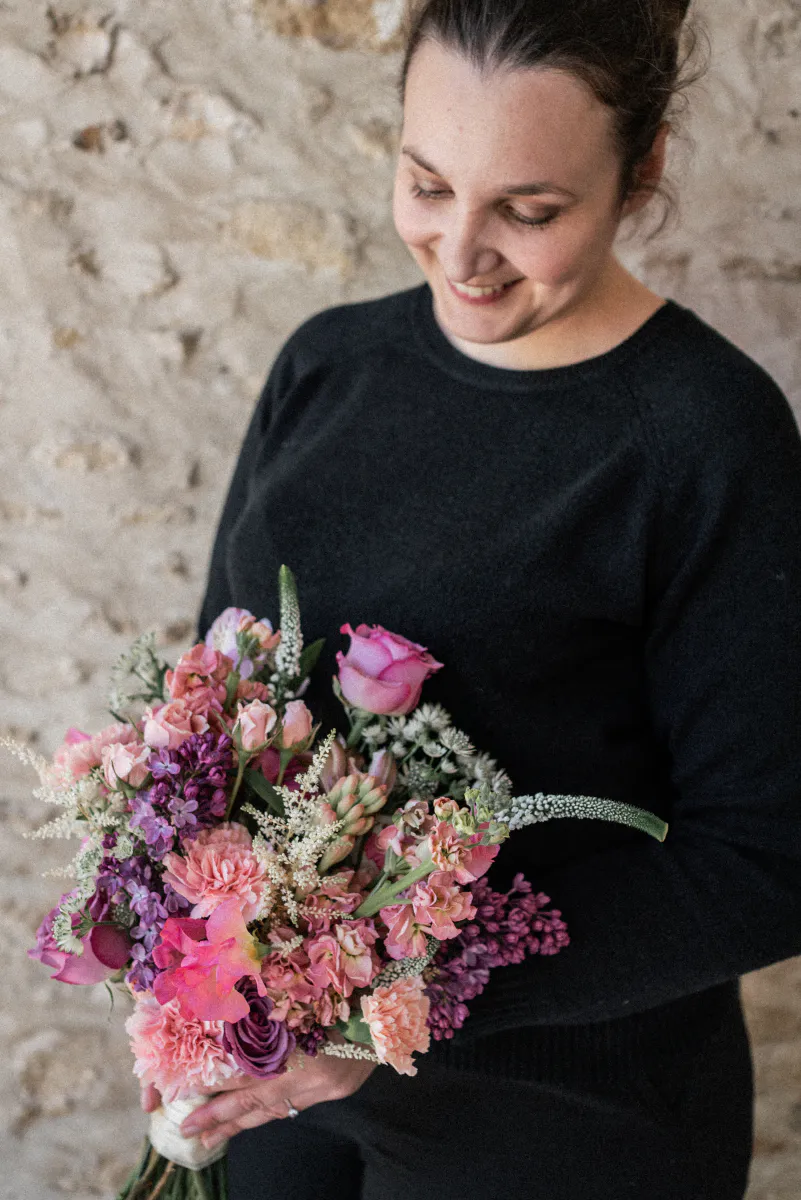 Mélissa Lois contemplant un bouquet aux tons roses et violets