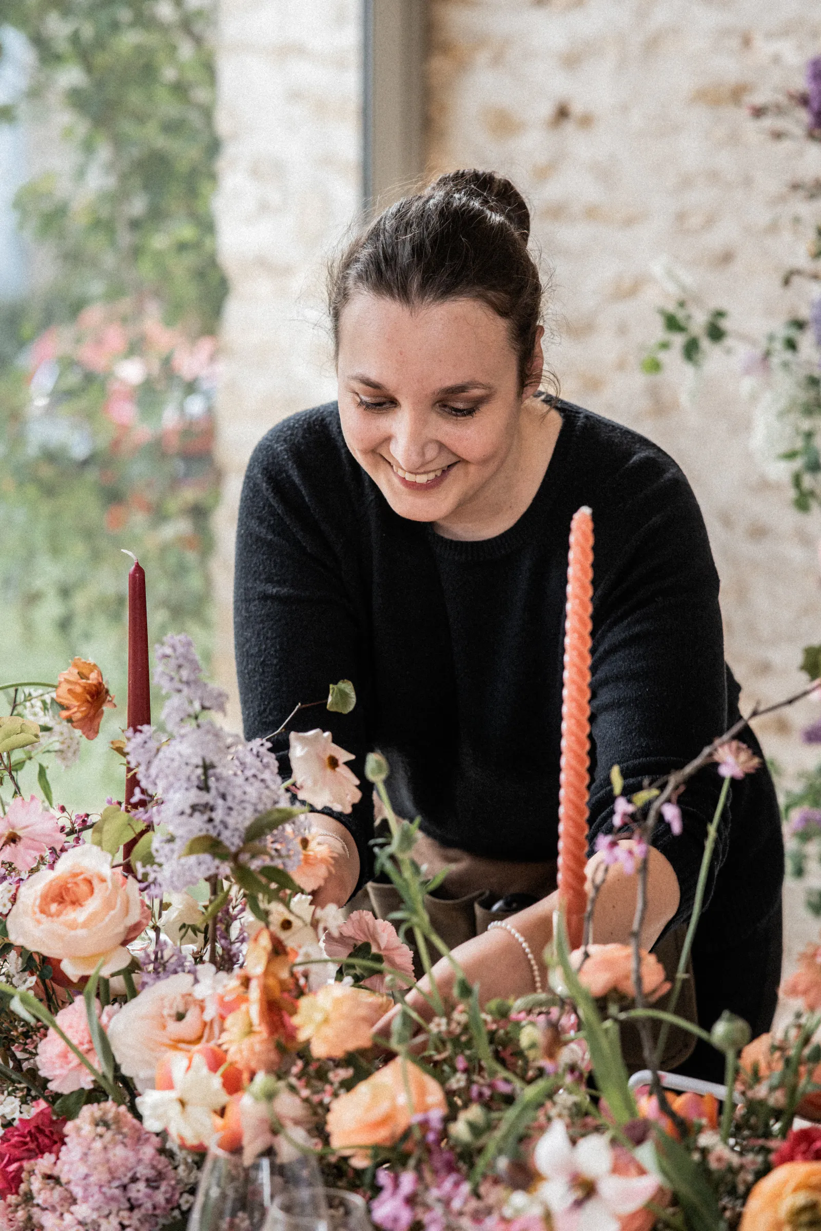 Mélissa Lois ajustant une composition florale lors de l'installation d'une table