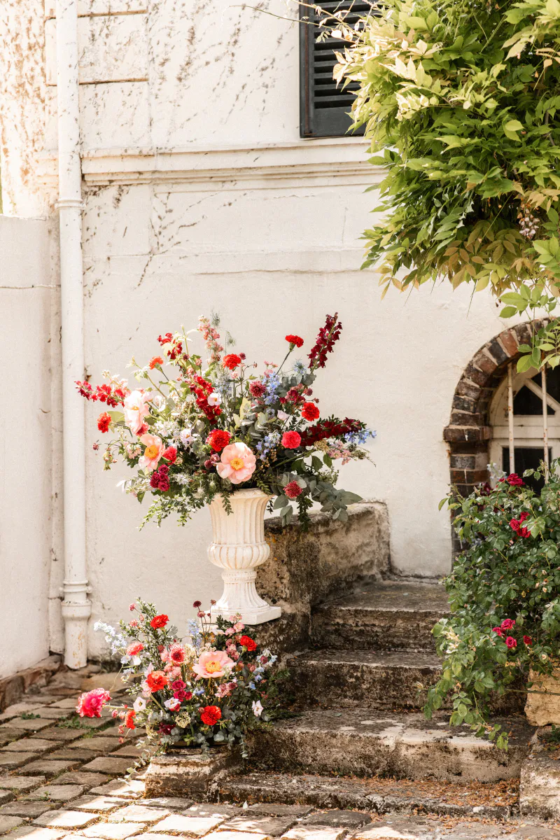Escalier fleuri et vasque aux fleurs rouges