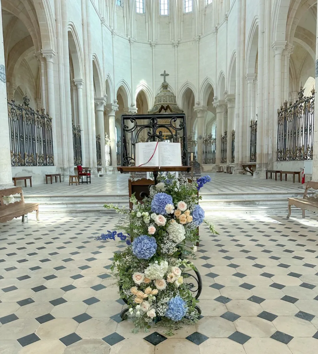 Composition florale bleue et blanche dans l'allée d'une cathédrale