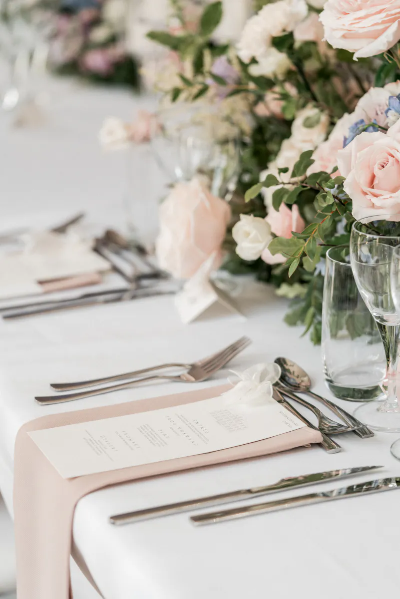 Détail de table aux roses poudrées et serviettes roses
