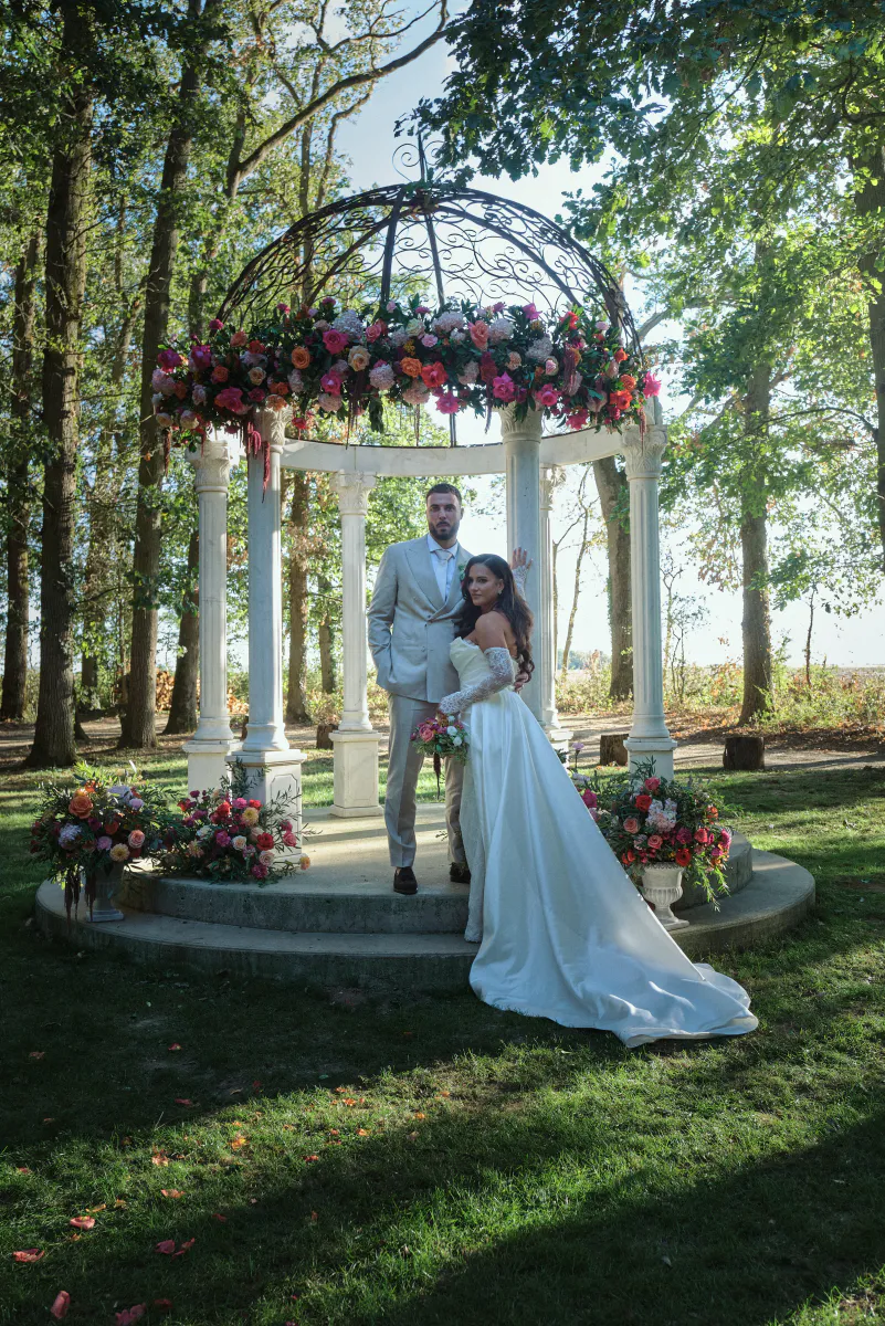 Mariés sous un kiosque couronné de fleurs