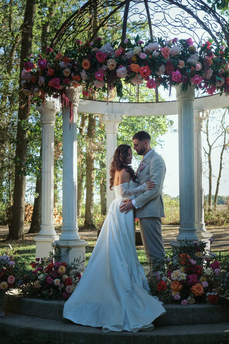 Kiosque à colonnes couronné de fleurs pour une séance photo de mariés