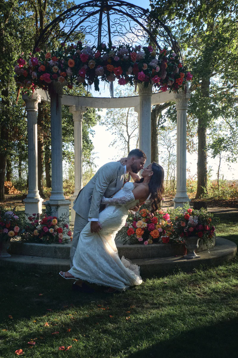 Baiser des mariés sous le kiosque fleuri