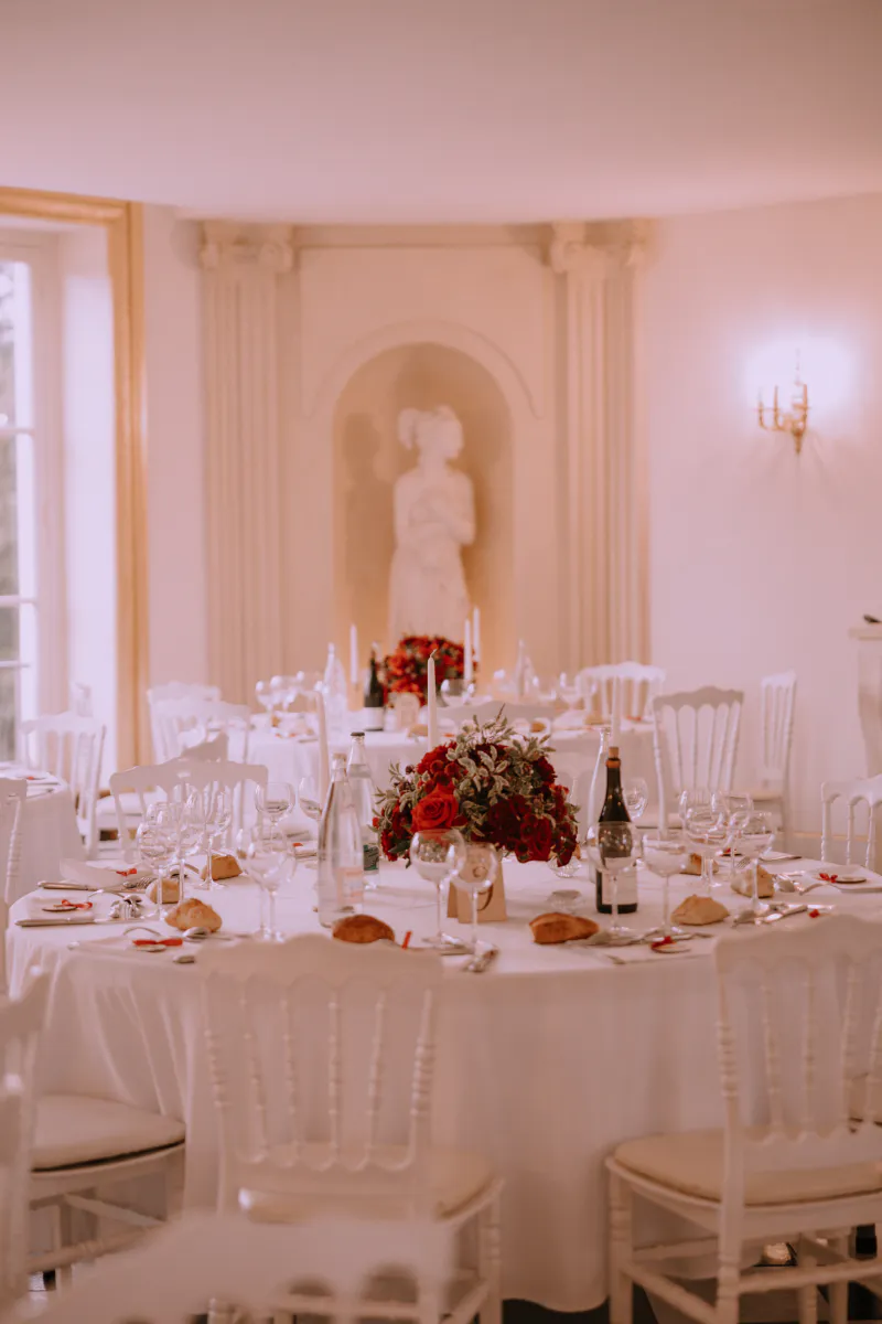 Salle de réception aux tables rondes ornées de roses rouges