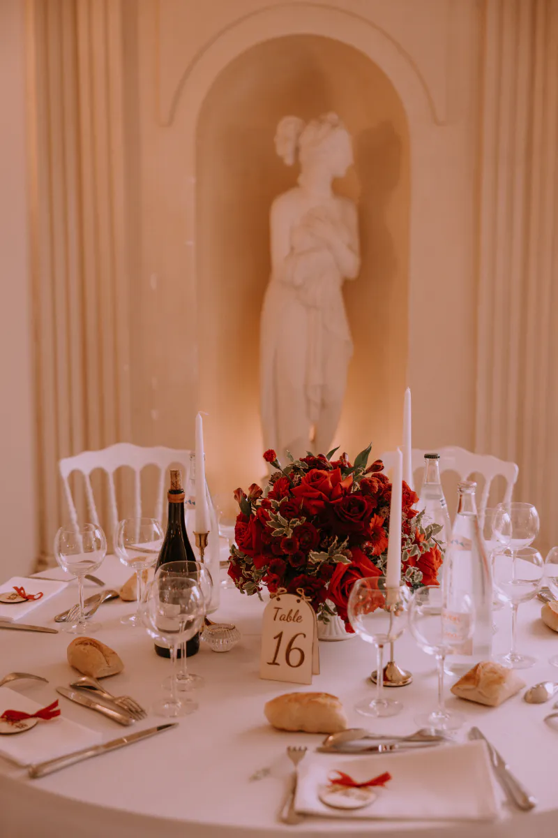 Table dressée aux roses rouges devant une statue